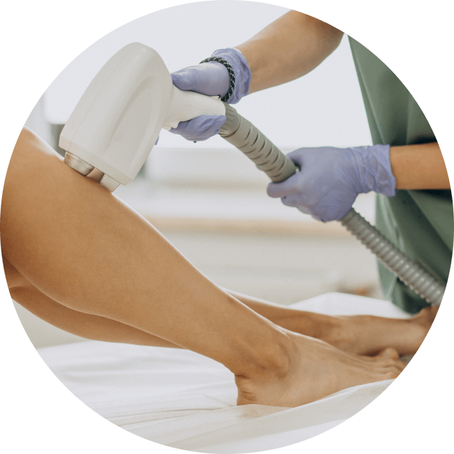 A healthcare professional wearing gloves using a laser hair removal device on a client's leg